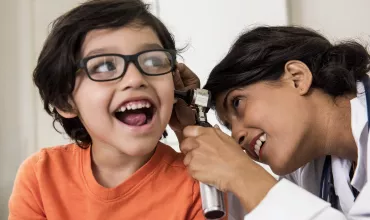 Doctor examining a young child's ear Doctor examining a young child's ear