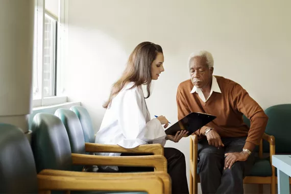 Doctor talking with a patient in a room Doctor talking with a patient in a room