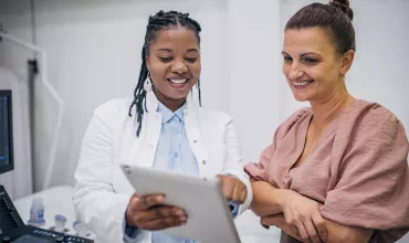 A doctor and patient discussing medical results on a tablet A doctor and patient discussing medical results on a tablet