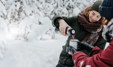 Venner med en kopp varm te på fjelltur Venner med en kopp varm te på fjelltur