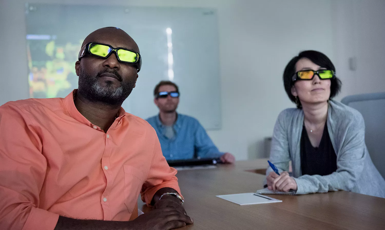 Group of business people watching at a screen using special glasses Group of business people watching at a screen using special glasses