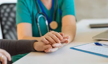 Healthcare professional holding the hands of an elder patient Healthcare professional holding the hands of an elder patient