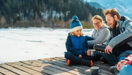 Eine Familie macht Pause neben einem Fluss