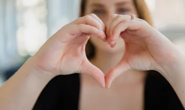 Mujer haciendo símbolo de corazón con sus manos Mujer haciendo símbolo de corazón con sus manos