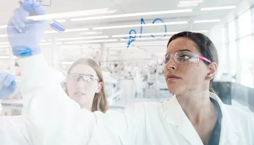 Un scientifique écrit sur un mur de verre