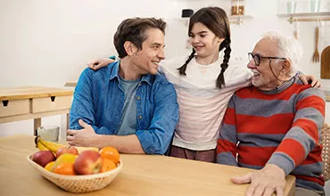Familie am Tisch Teaser Patient*innen & Angehörige 220px