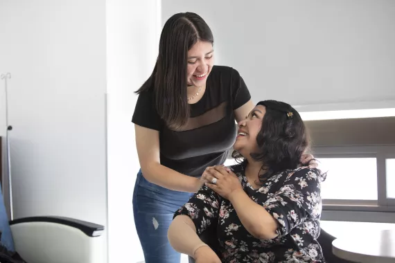 Paciente y cuidadora mirandose y abrazandose Paciente y cuidadora mirandose y abrazandose